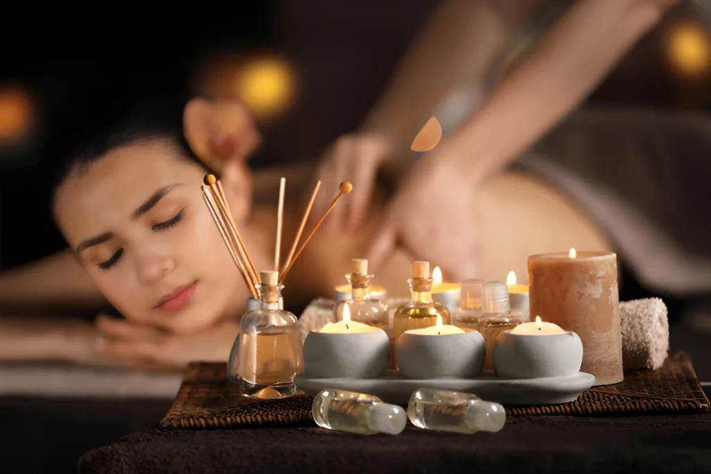 Peaceful spa setup with aroma candles, essential oils, and a woman enjoying aromatherapy massage in Bangalore.
