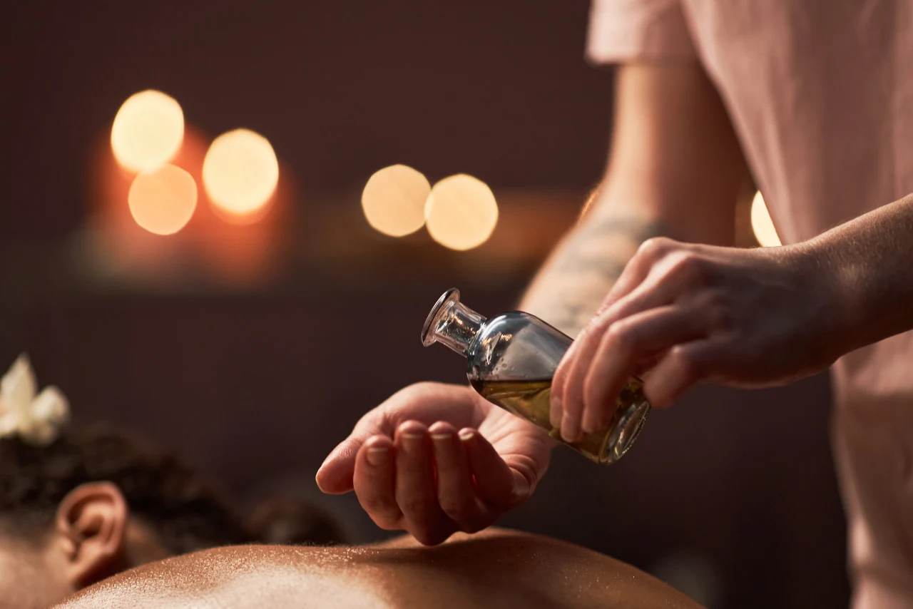 Therapist performing soothing hot oil massage using natural essential oils